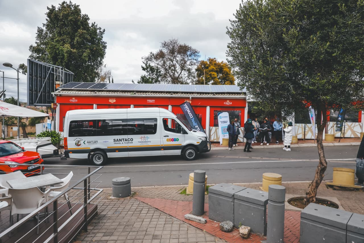 SANTACO minibus parked outside red storefront
