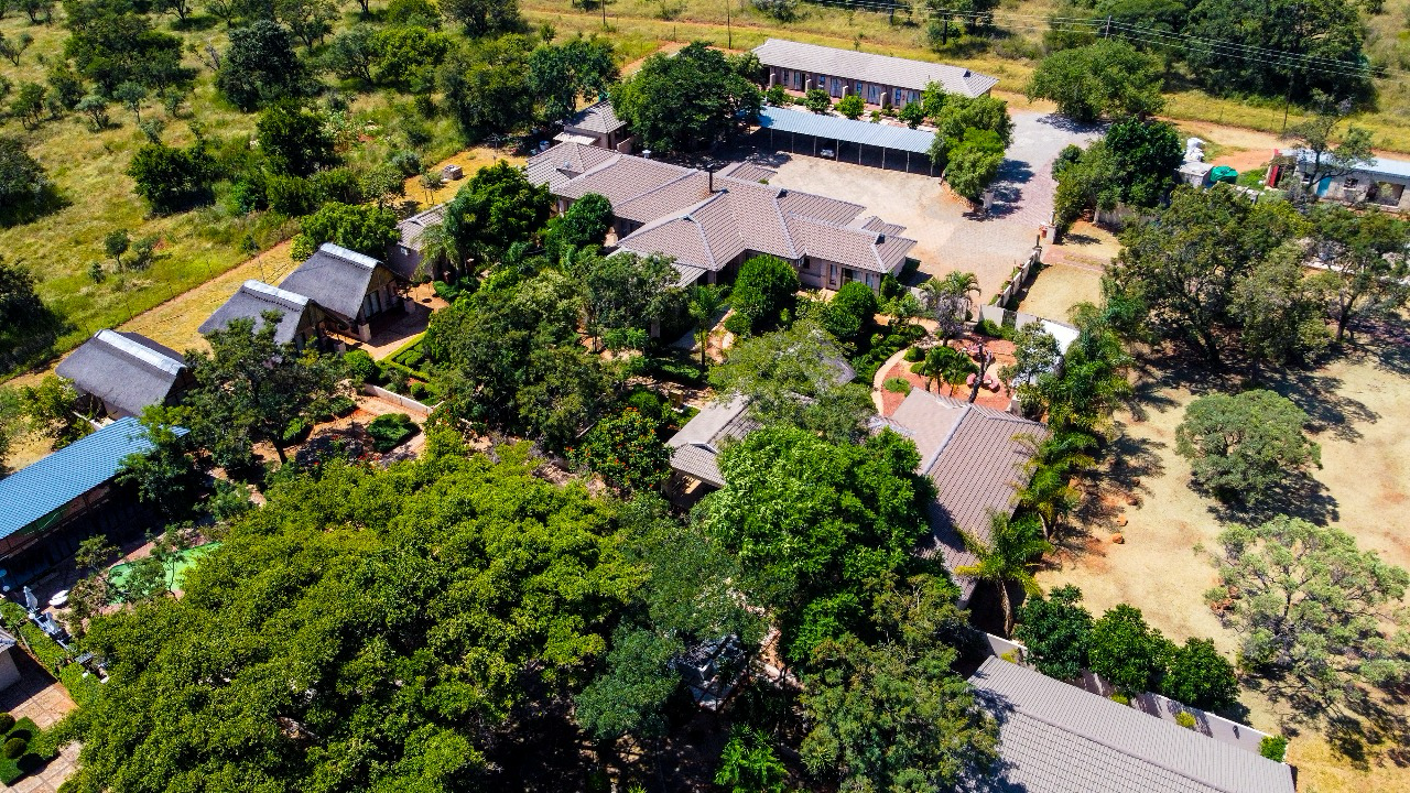 Aerial view of leafy lodge buildings in bushveld