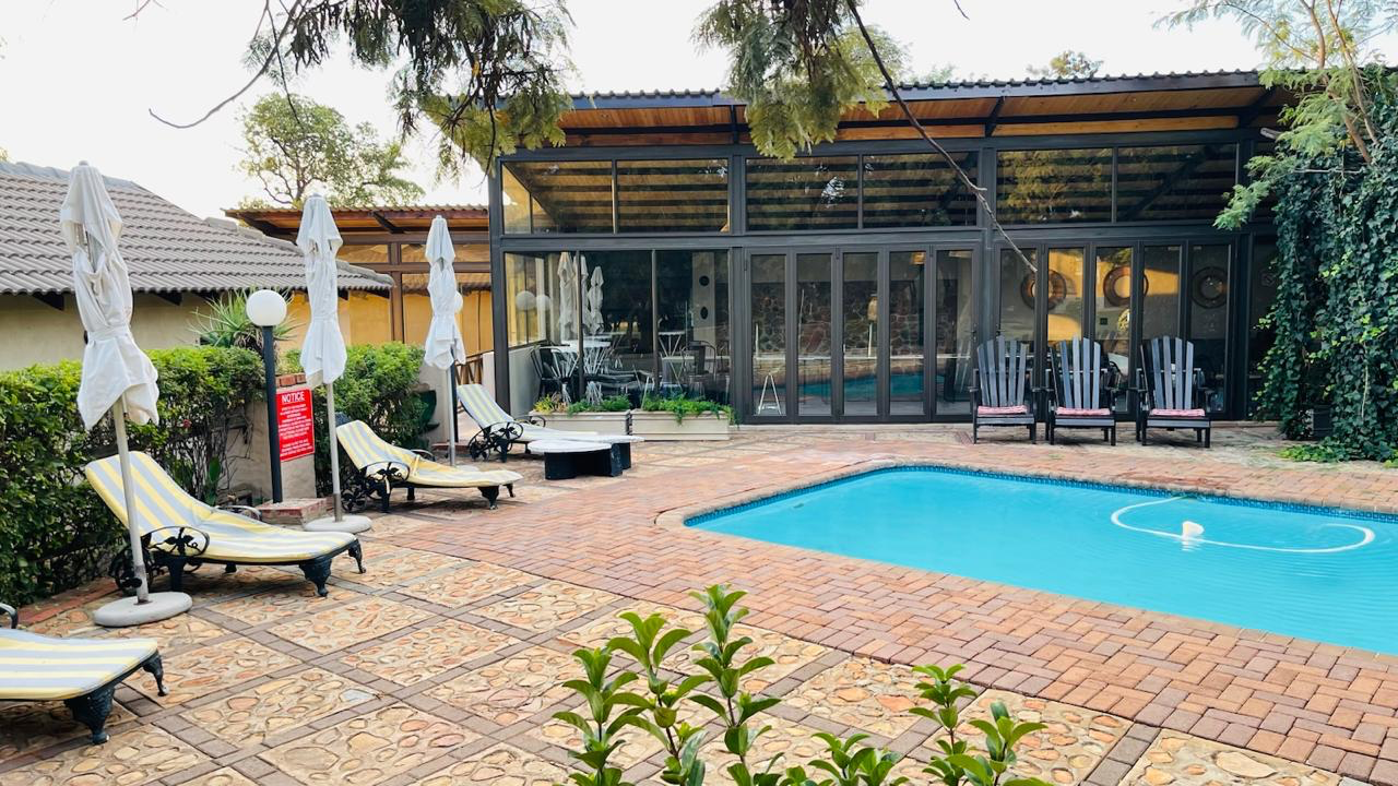 Outdoor pool patio with loungers and modern glass building