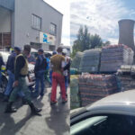 Police and workers near warehouse and stacked goods.