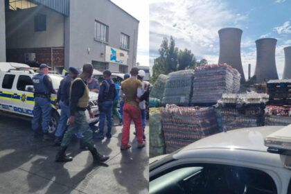 Police and workers near warehouse and stacked goods.
