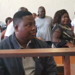 People gathered in a courtroom setting.