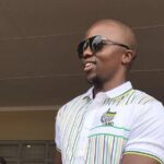 Smiling man wearing sunglasses and ANC shirt.