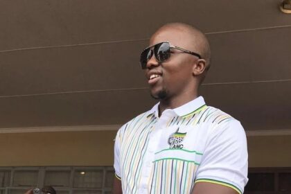 Smiling man wearing sunglasses and ANC shirt.