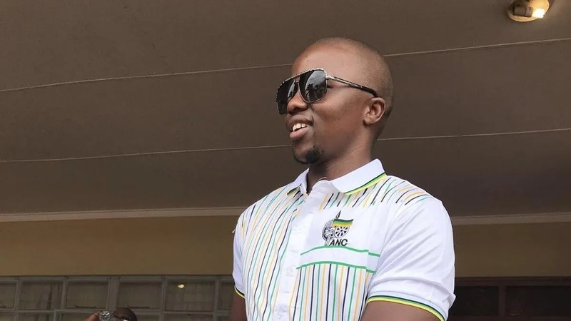 Smiling man wearing sunglasses and ANC shirt.