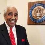 Man smiling near U.S. House of Representatives plaque.