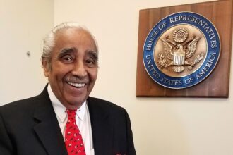 Man smiling near U.S. House of Representatives plaque.