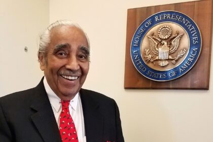 Man smiling near U.S. House of Representatives plaque.