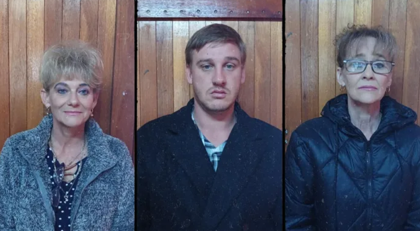 Three individuals against wooden background