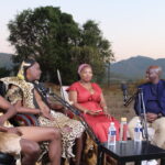 Outdoor podcast interview with four people and microphones.