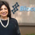 Smiling woman in front of Biocon sign.