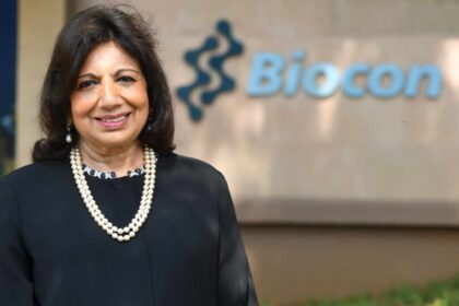 Smiling woman in front of Biocon sign.