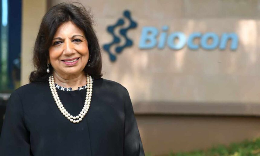 Smiling woman in front of Biocon sign.