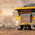 Mining truck transporting ore on dirt road.