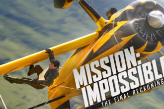 Person hanging on yellow plane in action scene.