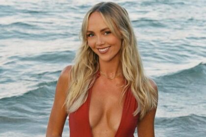Smiling woman in red swimsuit at the beach.