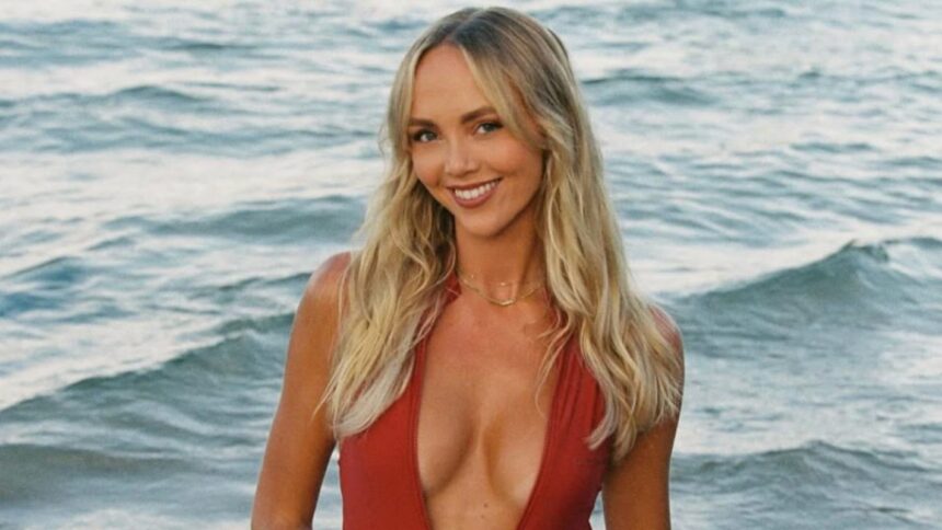 Smiling woman in red swimsuit at the beach.