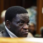 Man in courtroom, intense expression.