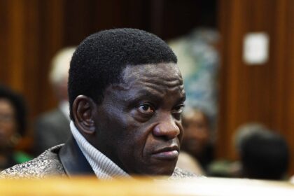 Man in courtroom, intense expression.