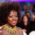 Smiling person in colourful necklace at event