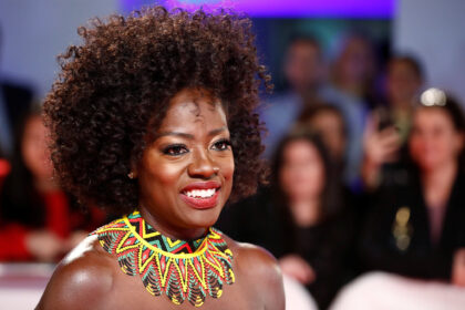 Smiling person in colourful necklace at event