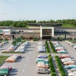 Shopping centre with parking lot and various stores.