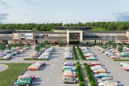 Shopping centre with parking lot and various stores.