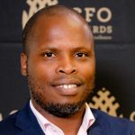 Man at CFO Awards event, smiling.