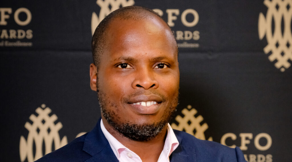 Man at CFO Awards event, smiling.