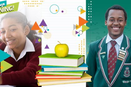 Two students smiling, apple on books, Keep Shining text.