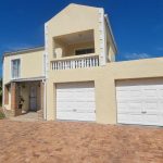 Double-storey yellow house with two garages.