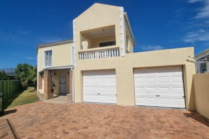 Double-storey yellow house with two garages.