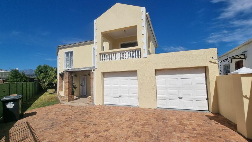 Double-storey yellow house with two garages.