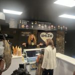Woman serving customers at an ice cream shop.