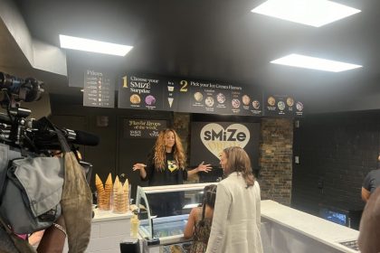 Woman serving customers at an ice cream shop.