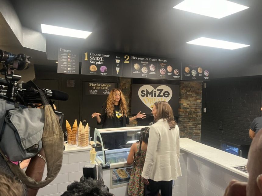 Woman serving customers at an ice cream shop.