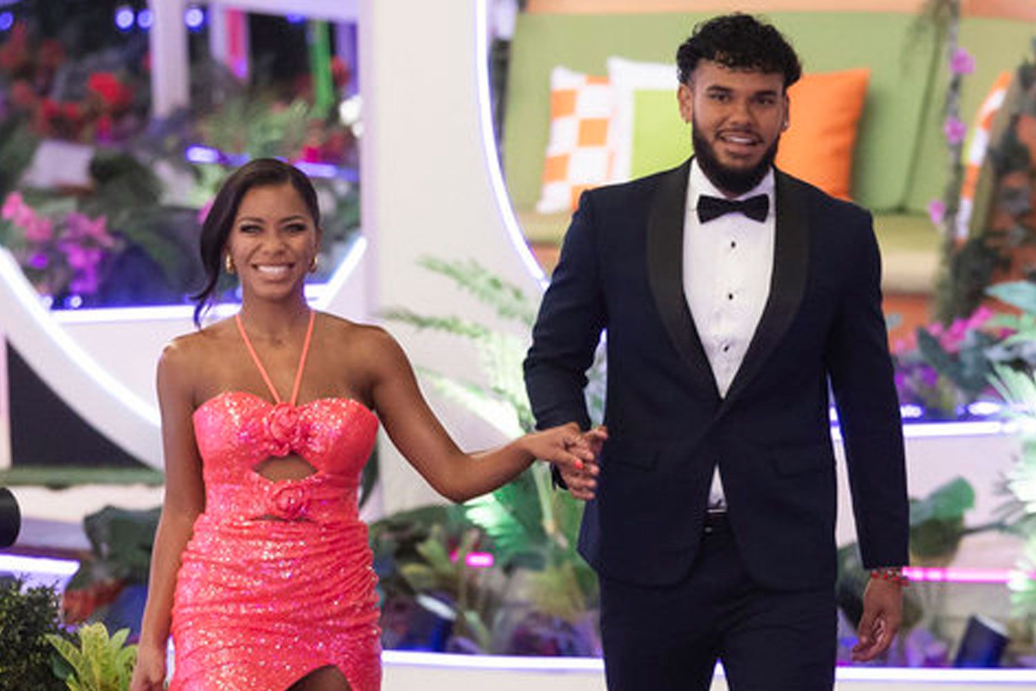Couple in formal attire on colourful set.