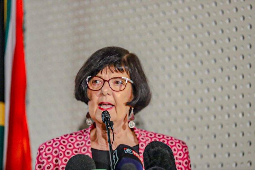 Woman speaking at a press conference podium.