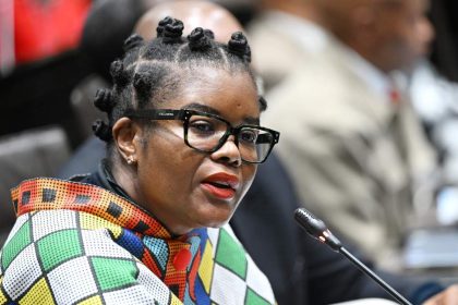 Person speaking at conference with colourful attire.