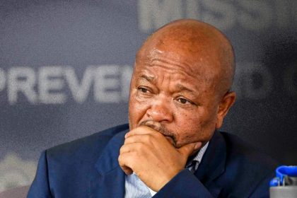 Thoughtful man seated at a press conference.