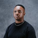 Person wearing black T-shirt and chain necklace.