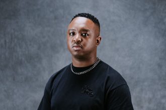 Person wearing black T-shirt and chain necklace.