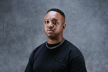 Person wearing black T-shirt and chain necklace.