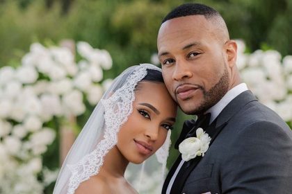 Elegant couple in wedding attire, outdoor setting.
