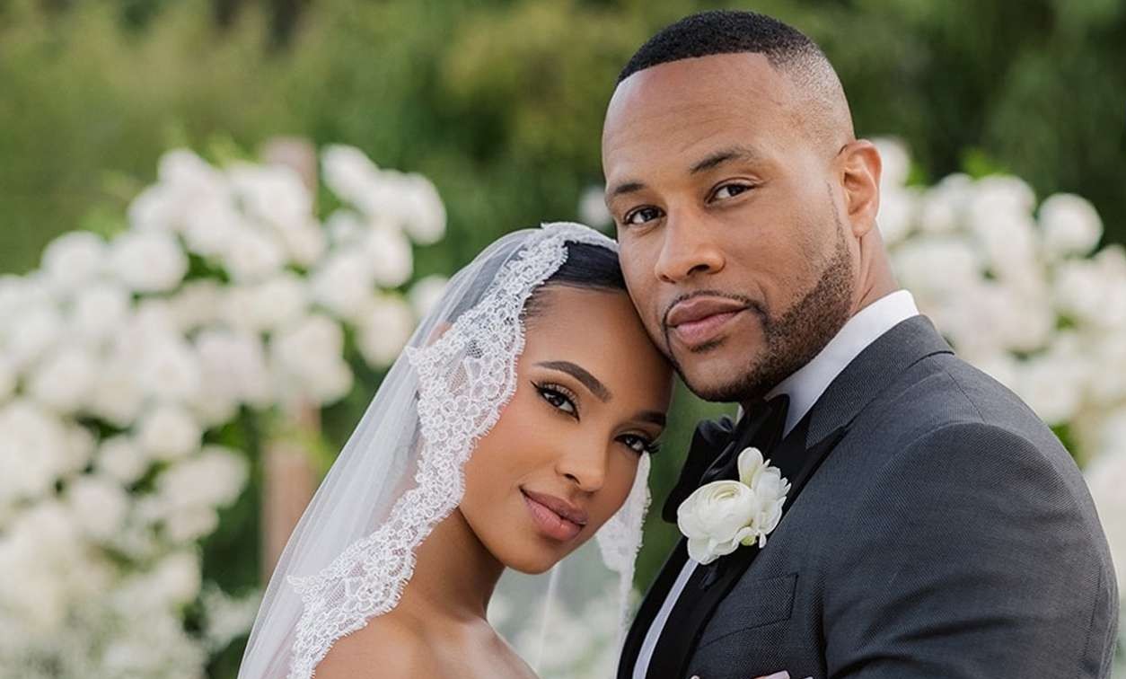 Elegant couple in wedding attire, outdoor setting.
