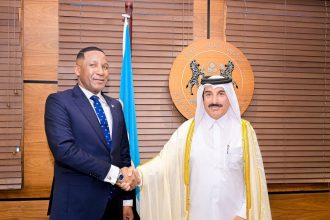 Two men handshake in formal attire.