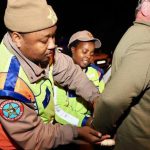 Traffic officers arresting man at night checkpoint