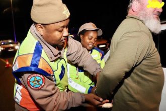 Traffic officers arresting man at night checkpoint