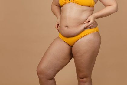 Person in yellow bikini on beige background.