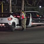 Traffic officer inspecting cars at night in South Africa.